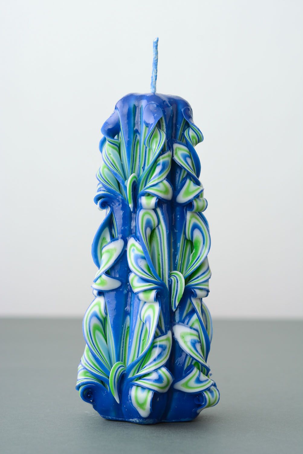 Highly carved candle in blue-green shades.