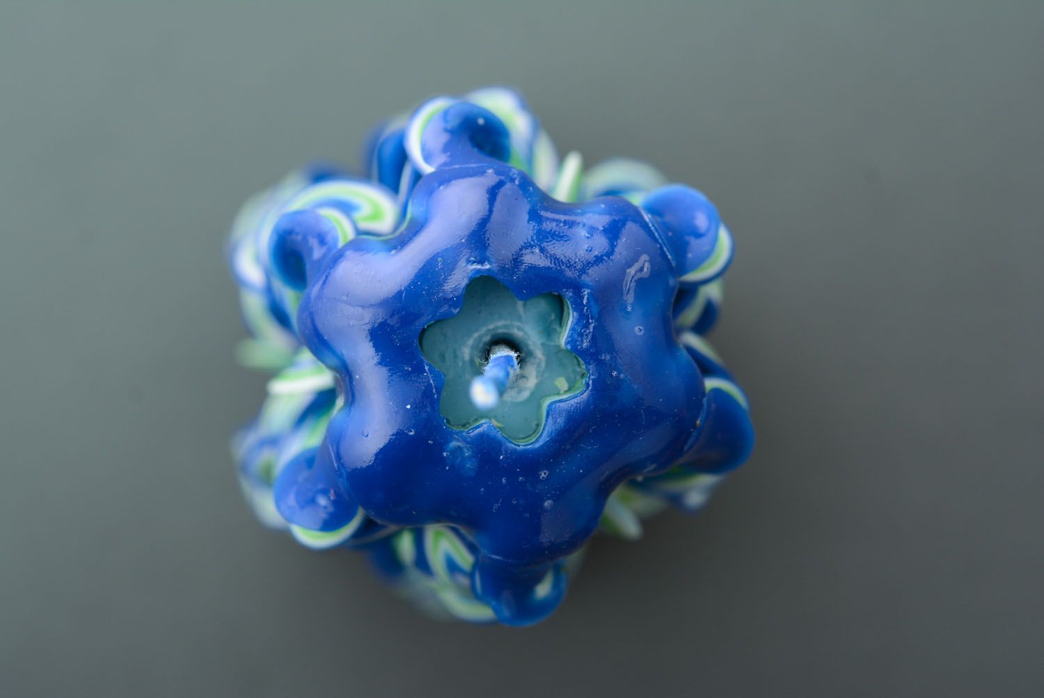 Highly carved candle in blue-green shades.